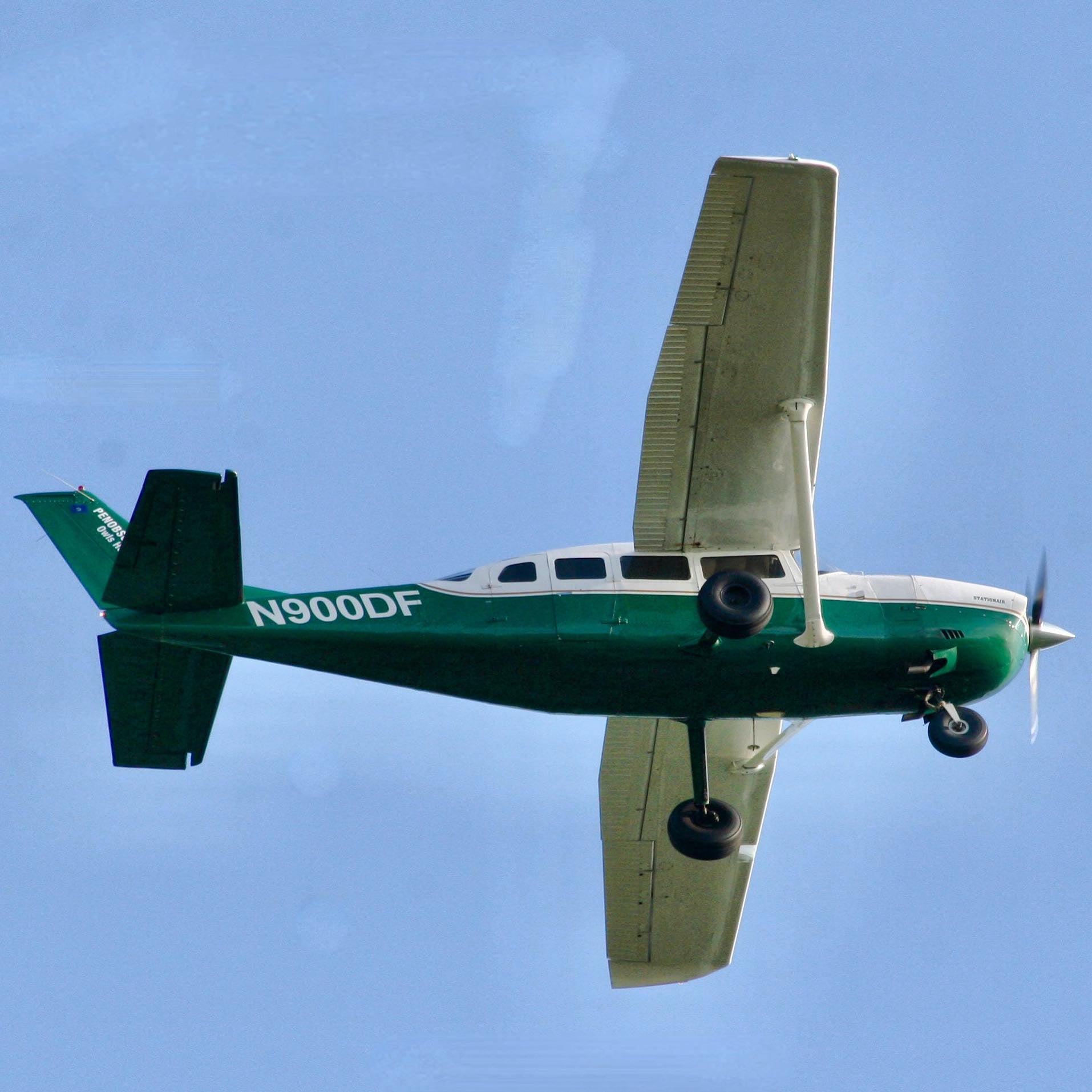 Green airplane with registration number N900DF against a blue sky