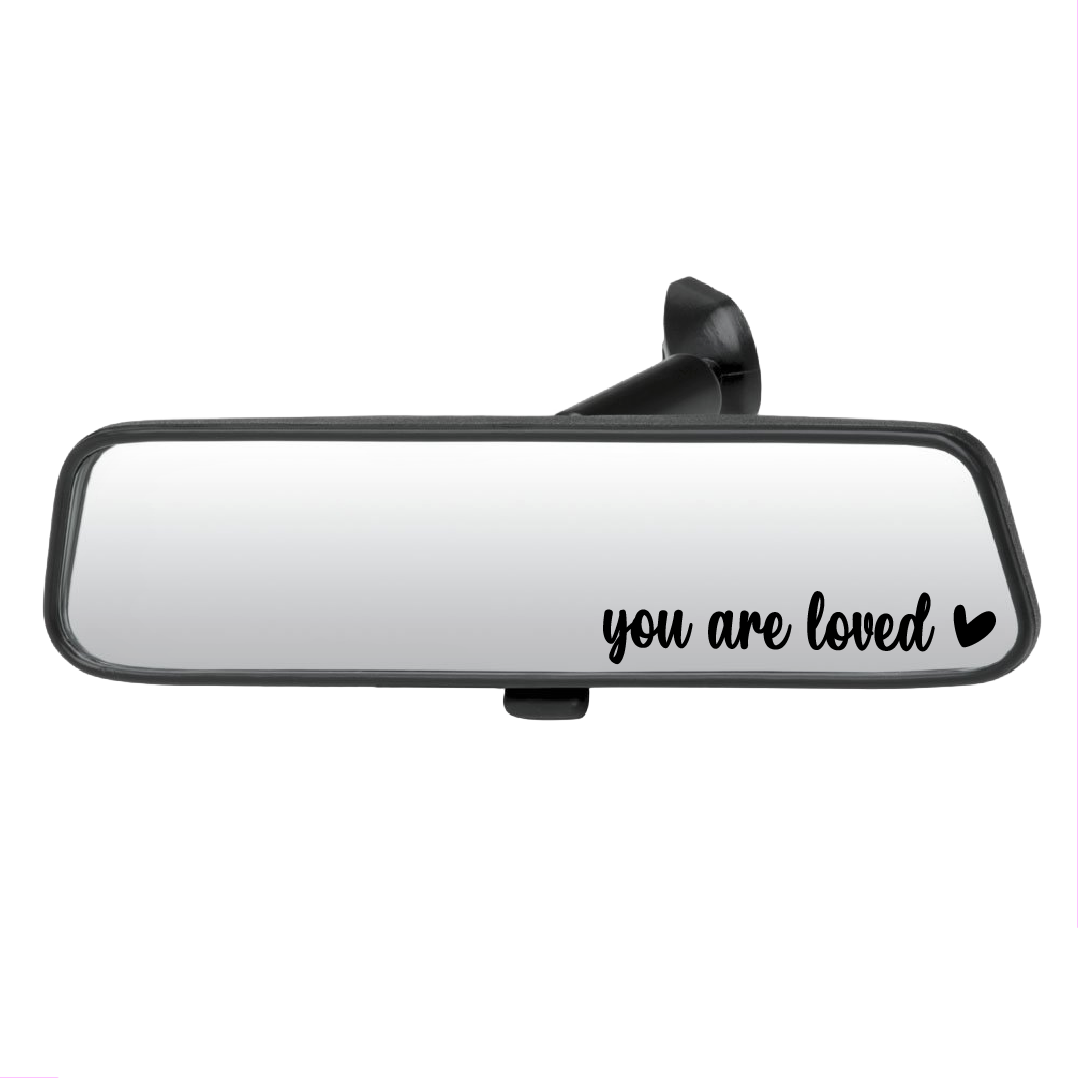 Car mirror with 'you are loved' text on a white background