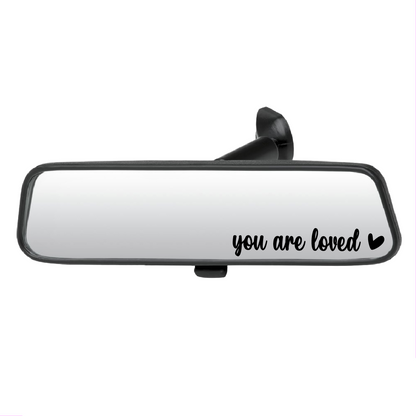 Car mirror with 'you are loved' text on a white background